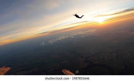 Silhouette Of Skydivers At Sunrise