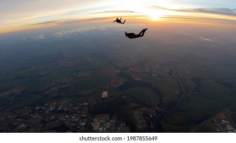 Silhouette Of Skydivers At Sunrise