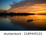 The silhouette of a small motorized canoe on the Guaporé - Itenez river at dusk, Ricardo Franco village, Vale do Guaporé Indigenous Land, Rondonia, Brazil, on the border with Bolivia