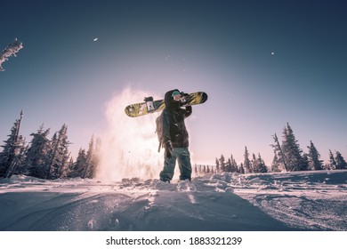 Silhouette de Snowboarder caminando sobre polvo de nieve cerca del bosque de abetos cubierto de nieve