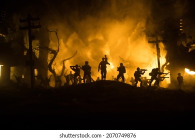 Silhouette Soldier Carrying Little Boy On His Shoulder From Fire. Rescue Savior Concept. Man Moving Out With Little Boy From Burned Out City Destroyed In War. Selective Focus