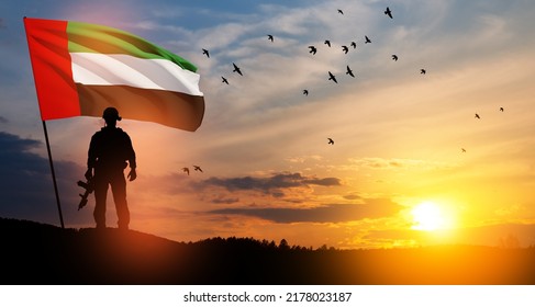 Silhouette Of Soldier With The Flag Of UAE Against Sunset Or Sunrise. Concept Of National Holidays. Commemoration Day.