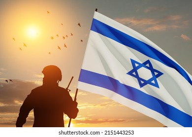 Silhouette of soldier with Israel flag against the sunrise in the desert. Concept - armed forces of Israel. Closeup.