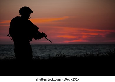 Silhouette Of Soldier With Rifle On A Sunset Dark Background. War, Military And Danger Concept.