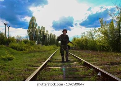 The Silhouette Of A Soldier Walking By Rail In The Overexposed Backlight Of The Sun. Lifestyle