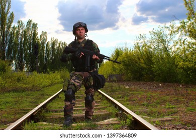 The Silhouette Of A Soldier Walking By Rail In The Overexposed Backlight Of The Sun. Lifestyle