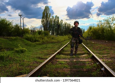 The Silhouette Of A Soldier Walking By Rail In The Overexposed Backlight Of The Sun. Lifestyle