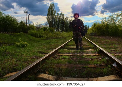 The Silhouette Of A Soldier Walking By Rail In The Overexposed Backlight Of The Sun. Lifestyle