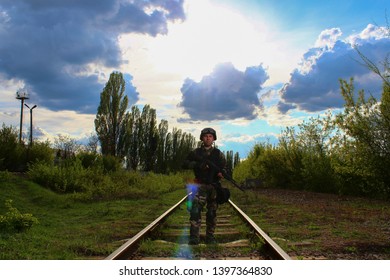 The Silhouette Of A Soldier Walking By Rail In The Overexposed Backlight Of The Sun. Lifestyle