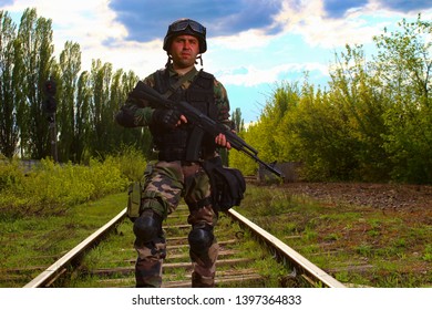 The Silhouette Of A Soldier Walking By Rail In The Overexposed Backlight Of The Sun. Lifestyle