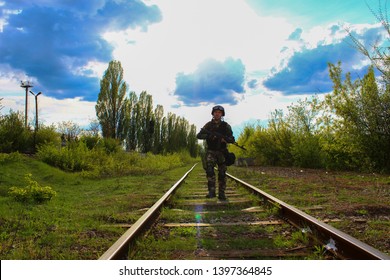 The Silhouette Of A Soldier Walking By Rail In The Overexposed Backlight Of The Sun. Lifestyle