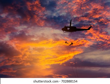    silhouette soldiers in action rappelling climb down from helicopter with military mission counter terrorism assault training on sunset   - Powered by Shutterstock