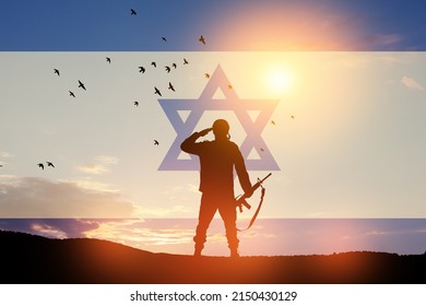 Silhouette of soldiers saluting against the sunrise in the desert and Israel flag.