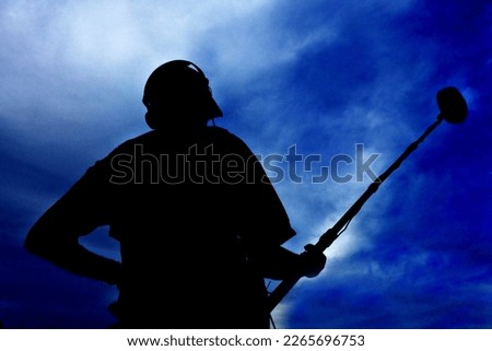 Silhouette of sound technician hold boom microphone isolated over dramatic blue sky.
Freedom of speech concept of hearing opinions and ideas without fear of retaliation, censorship or legal sanction