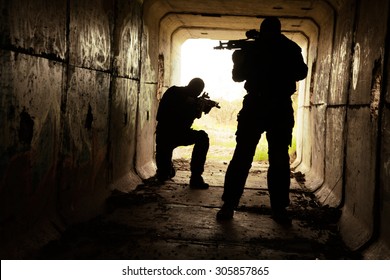 Silhouette Of Special Forces Operators With Weapons In The Tunnel