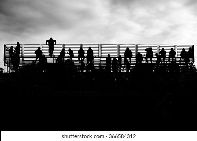 Silhouette Of Spectators Watching A Drag Race.