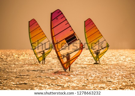 Silhouette sportsman is windsurfing at sunset time on wind of wave at Jomtien beach, Thailand