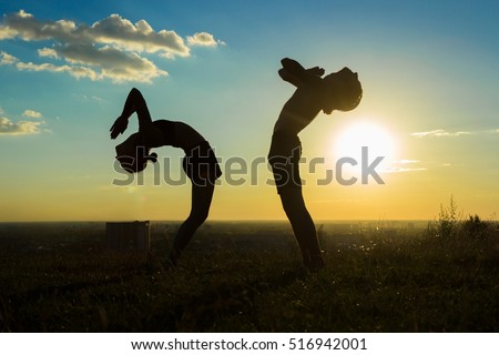 Similar – Two sisters doing gymnastics at sunset