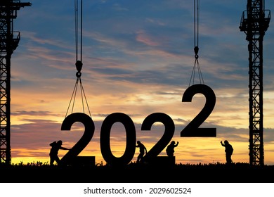 Silhouette of staff works as a team to prepare to welcome the new year 2022 - Shutterstock ID 2029602524