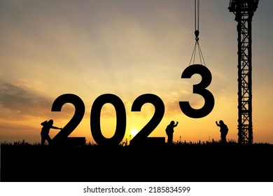 Silhouette of staff works as a team to prepare to welcome the new year 2023 - Shutterstock ID 2185834599