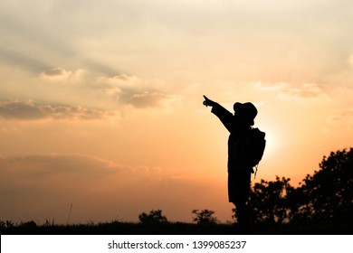 Silhouette of standing boy with hand pointing on sunset - Powered by Shutterstock