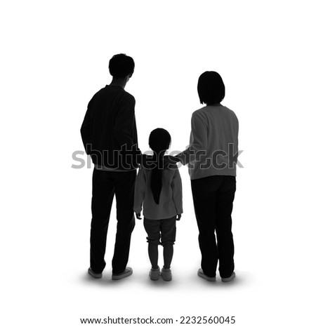 Silhouette of standing little girl and parents rear view.