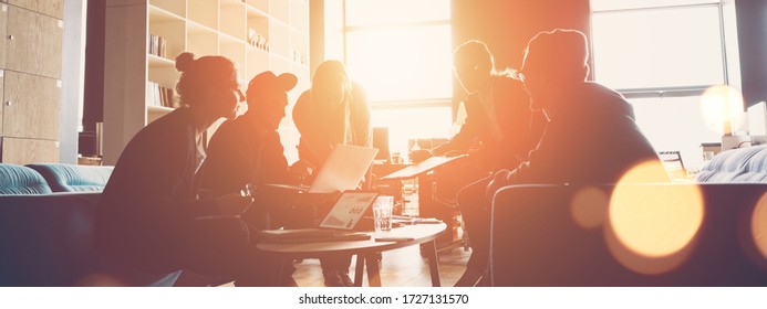 Silhouette Of Startup Business Team. Meeting On The Couch. Big Open Space Office. Five People. Intentional Sun Glare And Lens Flares. Wide Screen, Panoramic