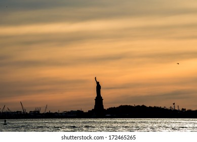 The silhouette of Statue of Liberty in New York City at sunset