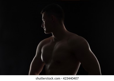 Silhouette Of Strong Athletic Man On Black Background