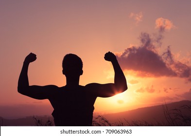 Silhouette of strong man flexing outdoors. People power and fitness goals.  - Shutterstock ID 709063963