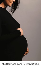 Silhouette Studio Photo Of Pregnant Woman In Black Dress Holds Her Pregnant Belly With A Copy Space For Text. The Concept Of Happy Motherhood. Love Concept