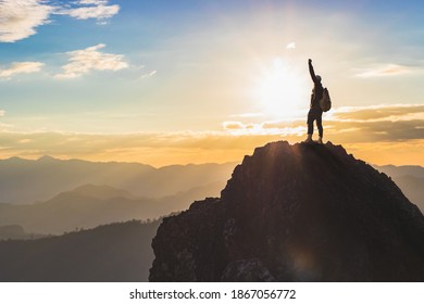 Silhouette Success male hiker with arms outstretched on top of mountain - Shutterstock ID 1867056772