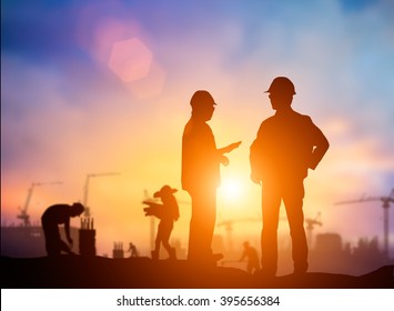 Silhouette Successful male engineer standing survey work on construction over blurred Worker in  construction site and nature