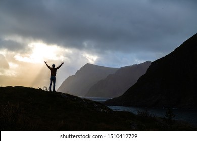 silhouette of successful man facing the beautiful landscape of ocean and mountain at top of hill. Concept for motivation and inspiration