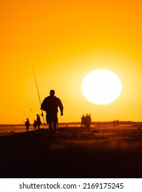 Silhouette Of A Surf Casting Fisherman On The Beach At Sunset. Jones Beach, Long Island New York