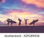 Silhouette Of surfer people carrying their surfboard on sunset beach, vintage filter effect with soft style