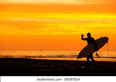 silhouette of a surfer at sunset - Powered by Shutterstock