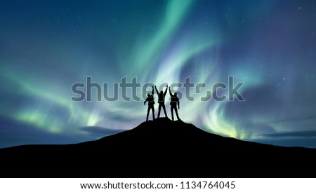Silhouette of a team at the northen light background. Sport and active life concept and idea of team
