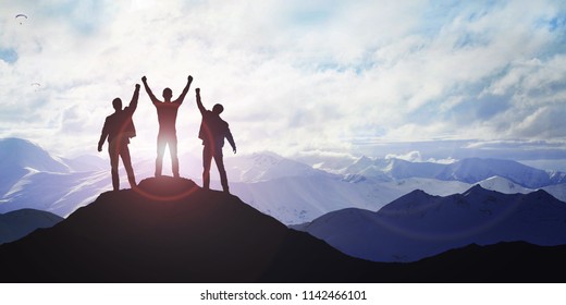 Silhouette of the team on the mountain. Leadership Concept