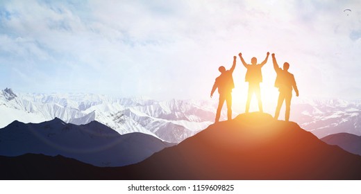 Silhouette of the team on the mountain. Leadership Concept - Shutterstock ID 1159609825