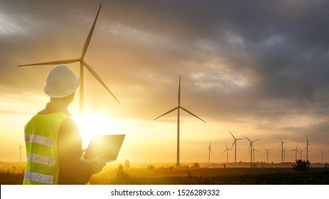 Silhouette Of Technician Engineer  At Wind Turbine Electricity Industrial In Sunset