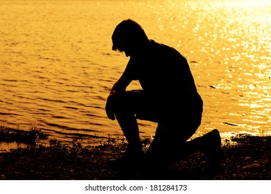 Silhouette Of Teenage Boy Kneeling Down