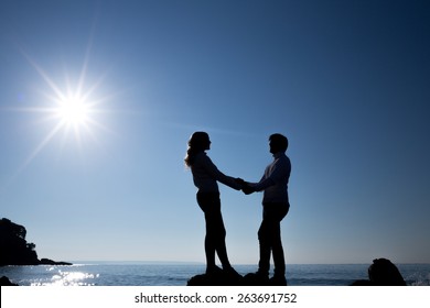 Silhouette Of Teenager Couple On The Beach