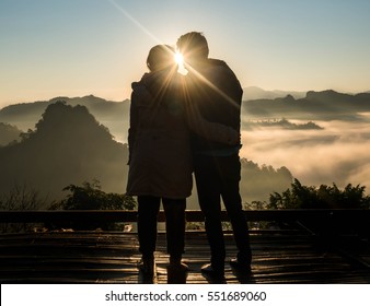 Silhouette Teenager Liebhaber paaren auf natürlichem Hintergrund am Berg und halten Hände Blick in die Sonne : schwarze Schatten liebenden Menschen Umarmung und Kuss:Liebe und Valentinkonzept.