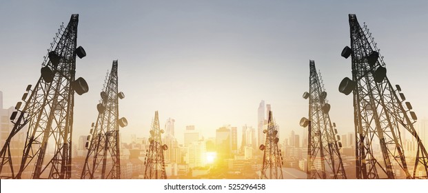 Silhouette, telecommunication towers with TV antennas and satellite dish in sunset, with double exposure city in sunrise background - Shutterstock ID 525296458