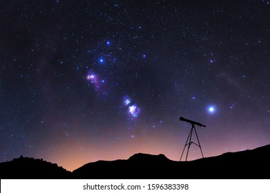 Silhouette of a telescope at the starry night and with Orion nebula. 