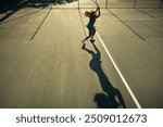 Silhouette of a tennis player on the court during a sunset session rally, emphasizing the dynamic motion and beautiful lighting.