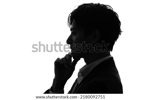 Silhouette of thinking asian businessman.