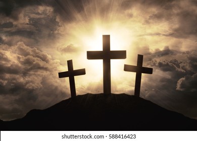 Silhouette of three crosses symbol on the mountain peak with sunbeam on the sky at sunrise