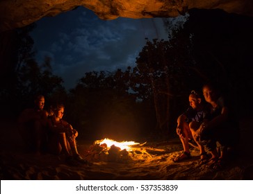 Silhouette of tourist girl around campfire at night on the river shore